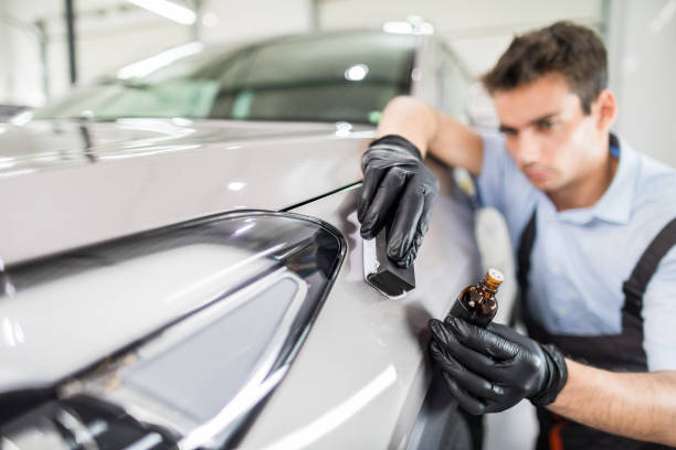LeWolf technician hand-applying ceramic coating to a silver vehicle