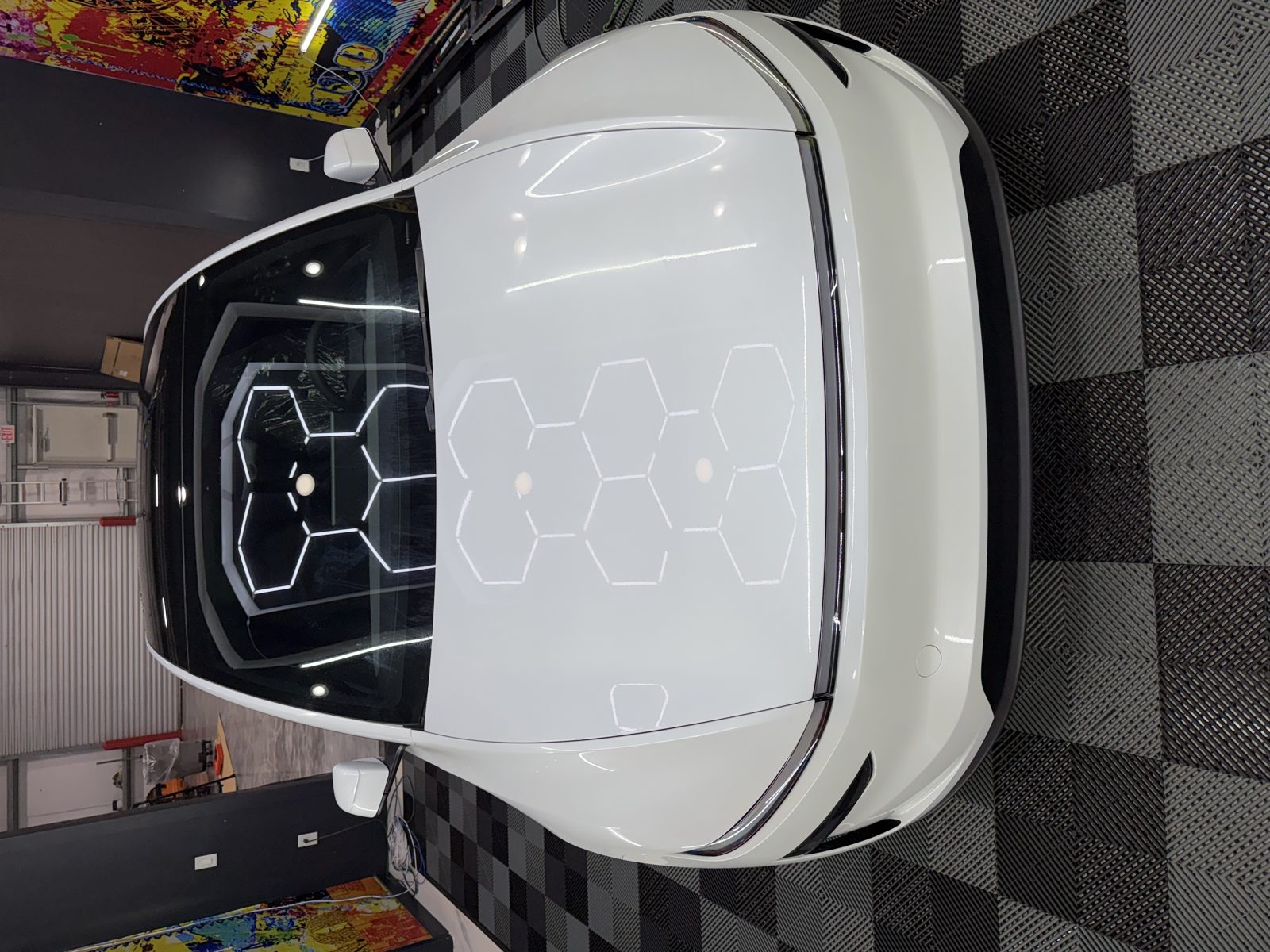 Paint protection film being applied to a red Tesla hood at LeWolf in Magnolia, TX