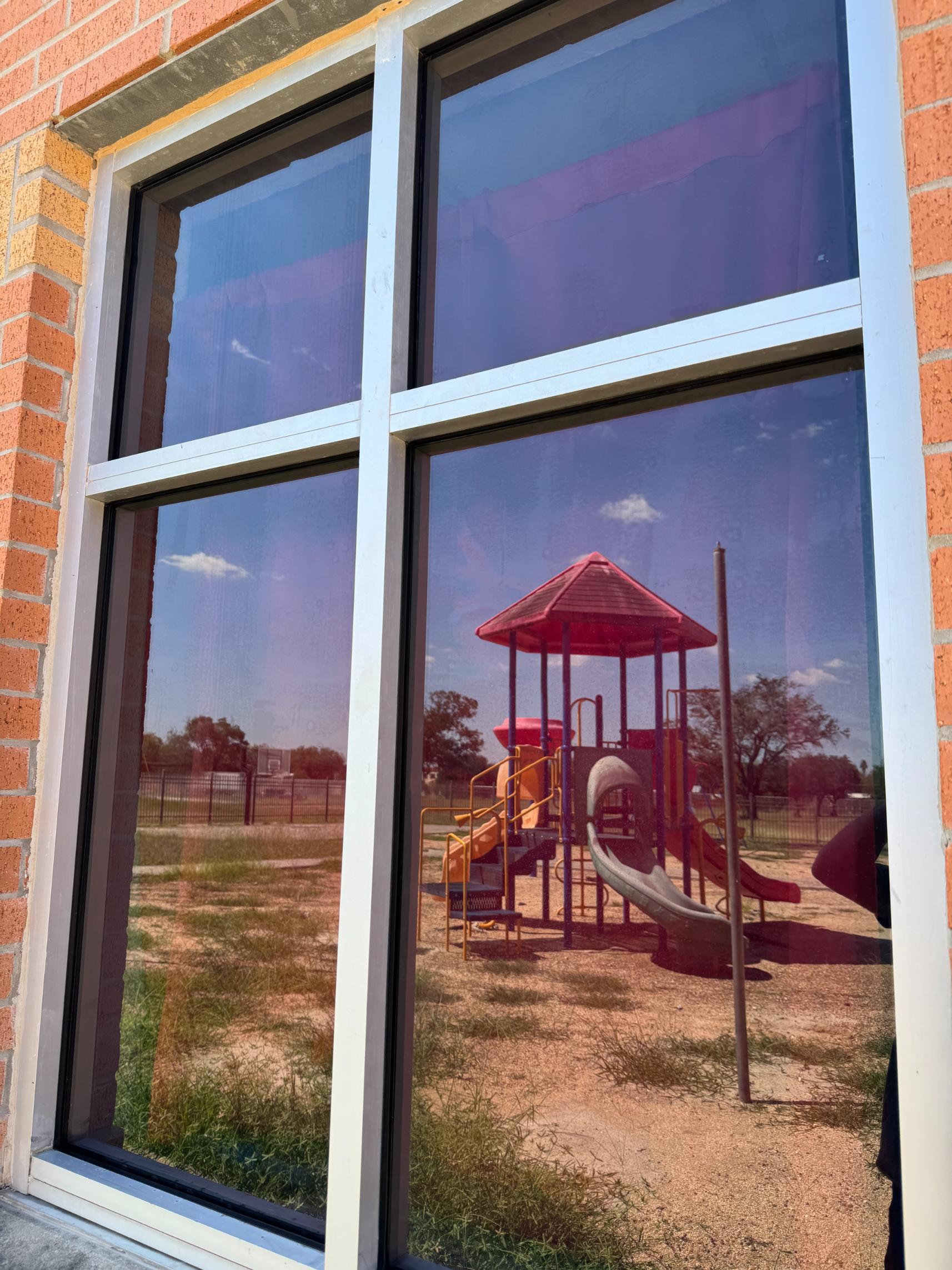 Playground reflected in a school window with security film in Harris County, TX